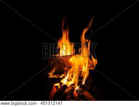 Colorful Lames Dance On Charred Logs In A Wood Fire. Closeup Of Fire Burning In An Old Fireplace, Ca