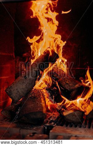 Colorful Lames Dance On Charred Logs In A Wood Fire. Closeup Of Fire Burning In An Old Fireplace, Ca