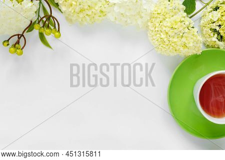 Сup Of Hot Tea With Bouquet Of Hydrangea On White Background. 

Spring Holiday Concept. 

Flat Lay, 