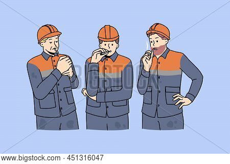 Male Workers In Uniforms Smoking Cigarette Outdoors. Men Builders At Work Have Job Break At Construc