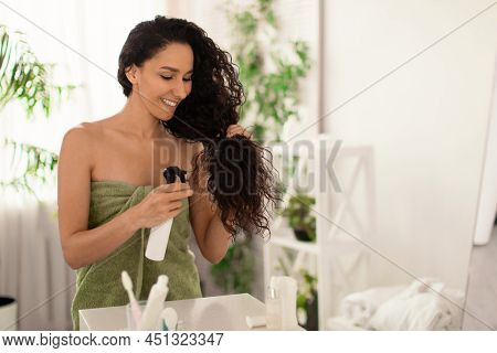 Split Ends Repair Treatment. Young Woman Applying Haircare Spray Or Natural Essential Oil On Hair Ne