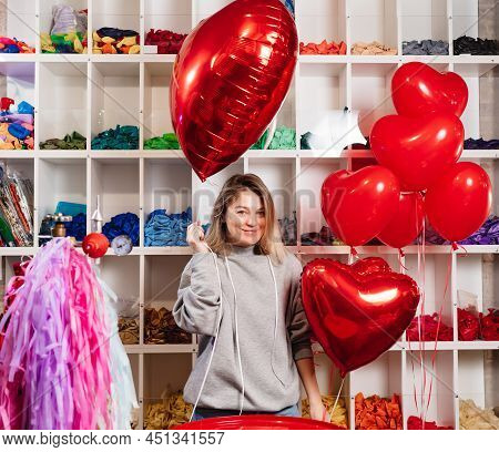 Woman With A Large Red Ball Of Foil In The Shape Of Heart.