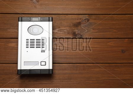 Modern Intercom System With Camera On Wooden Background, Top View. Space For Text