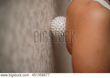 Athletic Slim Caucasian Woman Doing Thigh Self-massage With A Massage Ball Indoors. Self-isolating M