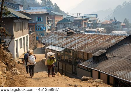 Phakding, Nepal - March 10, 2022: A Porter On The Trail To Everest Base Camp In The Small Village Of
