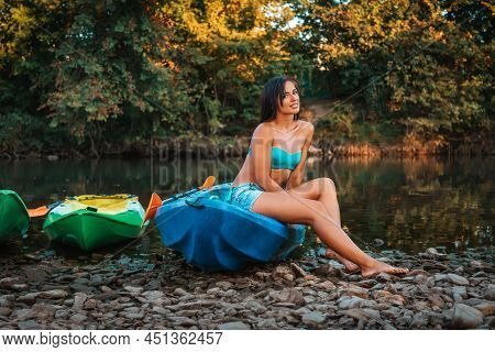 Kayaking. A Beautiful Smiling Young Woman In A Poses Sitting On A Kayak. Recretion At The National P