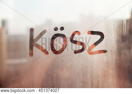 Handwritten Lettering Thanks In Hungarian Kosz On Misted Rainy Sunrise Glass On Orange Window Floode