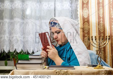 A Female Rabbi Of A Reform Judaism Community On Kisui Rosh Puts A Siddur To Her Forehead. Horizontal