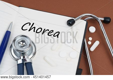 Medicine And Health Concept. On A Brown Surface Lie Pills, A Pen, A Stethoscope And A Notebook With 