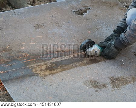 Cutting An Old Sheet Of Iron With A Grinder Top View, Recycling Used Metal By Separating Into Parts,