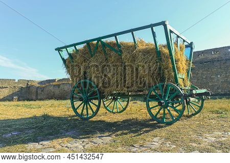 A Green Wooden Cart With Hay On The Background Of The Stone Walls Of The Belgorod-dnestrovskiy Fortr