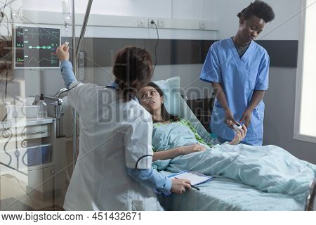 Nurse Putting Pulse Oximeter On Patient Finger While Doctor Setting Up Central Line Catether With Iv