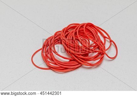 Small Pile Of Red Rubber Bands Elastic At Table