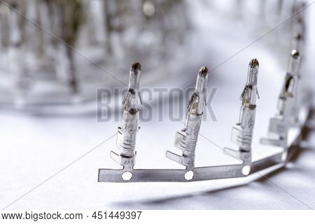 Electronic Concepts. Closeup Of Line Of Silver Tinned External Pcb Angular Connectors Over White Bac