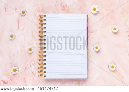 Open Notepad And Fresh Spring Daisy Flowers, Pastel Background, Woman Desk Workspace. Spring Lifesty