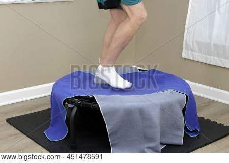 White Adult Male Legs Rebounding In A Right Side View On A Black Bungee Cord Rebounder With Two Towe