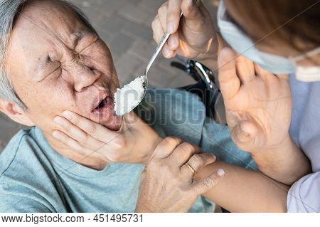 Force-feeding Because Asian Senior Woman Refuses,does Not Want To Eat Food,angry Female Caregiver Sc