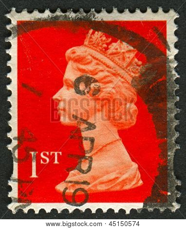 UK-CIRCA 1990:A stamp printed in UK shows image of Elizabeth II is the constitutional monarch of 16 sovereign states known as the Commonwealth realms, in red, circa 1990.