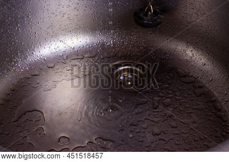 A Drop Of Pure Water Dripping From The Tap. Selective Focus. High Quality Photo