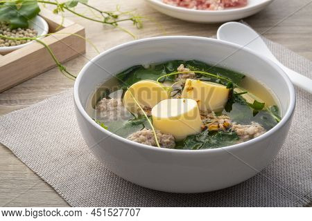 Clear Ivy Gourd Soup With Minced Pork And Egg Tofu In White Bowl On Wooden Table,thai Food.(gaeng Ju