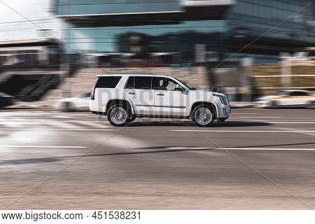 Fast Moving White Cadillac Escalade On Speedway Road. Overspeed In City Concept. Suv Car On City Roa