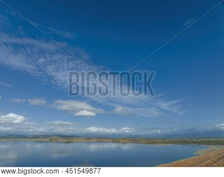 Aerial Landscape Of The Still Waters Of A Dam On A Calm Day With Wispy Clouds Overhead Reflected On 