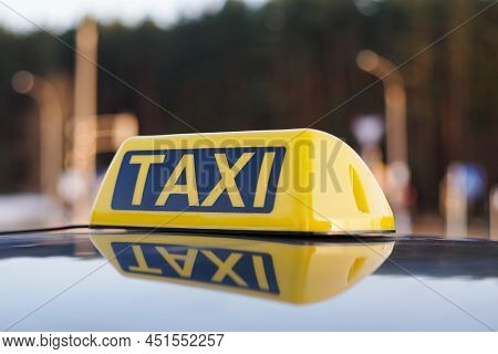 Close Up Of Taxi Cab Sign On A Car Roof. Daytime Traffic On The Background.