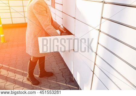 Pickup Parcel. Courier Box In Woman Hands At Post Delivery Automat Terminal. Self Service Post Termi