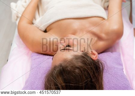 Facial Massage. A Woman Is Given A Massage In A Beauty Salon. Close-up.