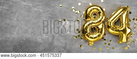 Yellow Foil Balloon Number, Number Eighty Four On A Concrete Background. Greeting Card With The Insc