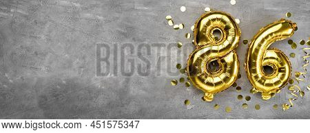 Yellow Foil Balloon Number, Number Eighty Six On A Concrete Background. Greeting Card With The Inscr