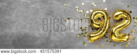 Yellow Foil Balloon Number Ninety Two On A Concrete Background. Greeting Card With The Inscription 9