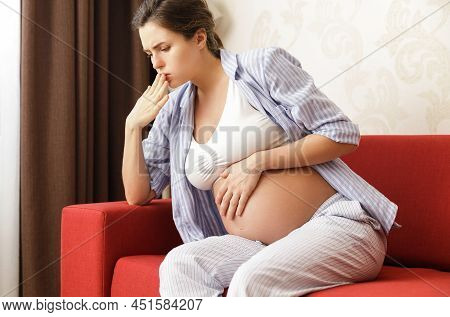 Young And Pregnant Woman At Home Feels Sick