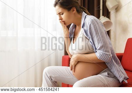Young And Pregnant Woman At Home Feels Sick