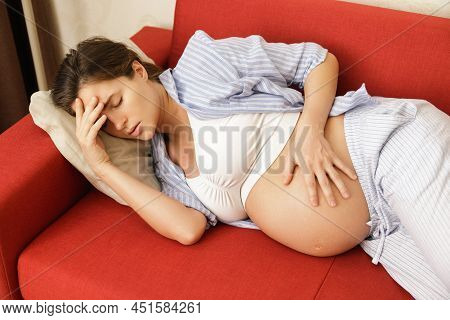 Young And Pregnant Woman At Home Feels Sick