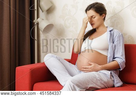 Young And Pregnant Woman At Home Feels Sick
