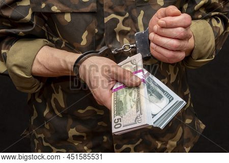 A Military Soldier Or Officer In Handcuffs Holds Bundles Of Dollar Bills In His Hands, Selective Foc