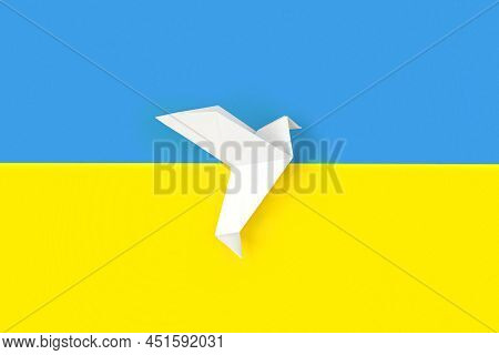 One White Origami Paper Dove On Colors Of Flag Of Ukraine. The Concept Of Peace Between Two States. 