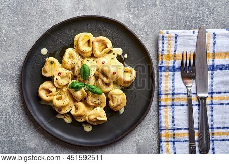 Italian ravioli pasta with pumpkin and basil on rustic background. Pumpkin pasta ravioli. Italian pasta ravioli. Creamy ravioli pasta tortellini on plate. Italian pasta dish ravioli. Pasta ravioli.
