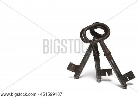 Close Up Of Three Old Retro Vintage Rusted Heavily Used Beard Keys Leaning Against Each Other On Whi