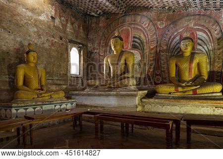 Dambulla, Sri Lanka - February 08, 2020: Ancient Sculptures Of A Sitting Buddha In The Interior Of A