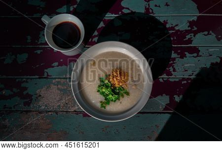 Pork Congee Or Rice Porridge With Minced Pork Sprinkled With Deep-fried Garlic And Coriander In Whit