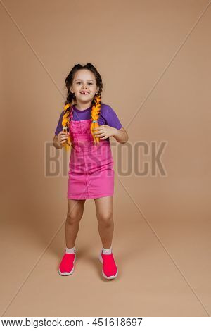 Active Indulging Little Girl Touching Two Kanekalon Pigtails Dancing Looking At Camera Smiling With 