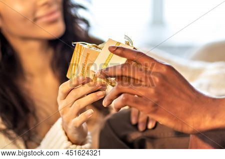 A Happy Couple Of Mulattoes Exchange Gifts With Each Other. Celebrating Joint Family Events.