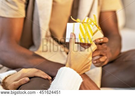 A Happy Couple Of Mulattoes Exchange Gifts With Each Other. Celebrating Joint Family Events
