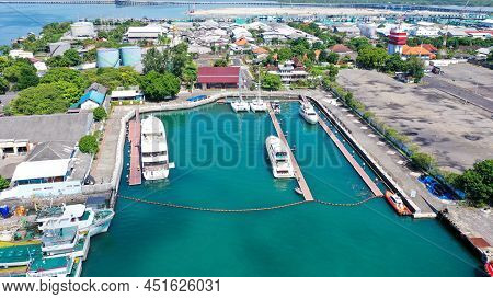 Aerial Of Beach, Pier, Boats, Resort And Businesses On Tip Of Tanyung Benoa Peninsula Above Dark Blu