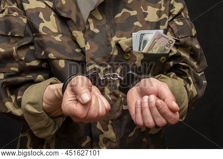 A Military Soldier Or Officer In Handcuffs, Bundles Of Dollar Bills Sticking Out Of His Pocket, Sele