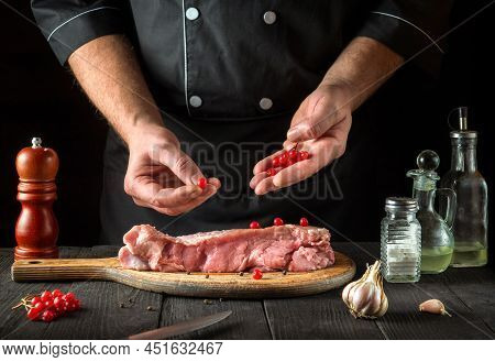The Chef Prepares Raw Calf Meat In Kitchen. Before Baking, The Cook Puts The Viburnum On The Beef. N