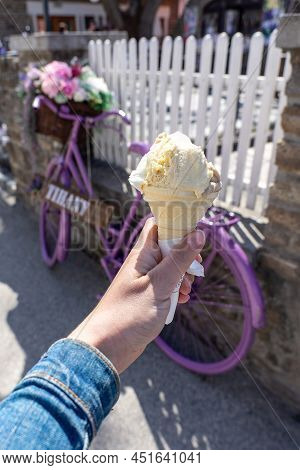 Woman Holding Ice Cream Cone With A Vintage Purple Bicycle Decoration In Tihany Hungary Next To Lake