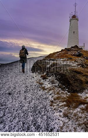Tourist Woman With Photographer Backpack Doing To The Lighthouse In Reykjanes Peninsula Reykjanesvit